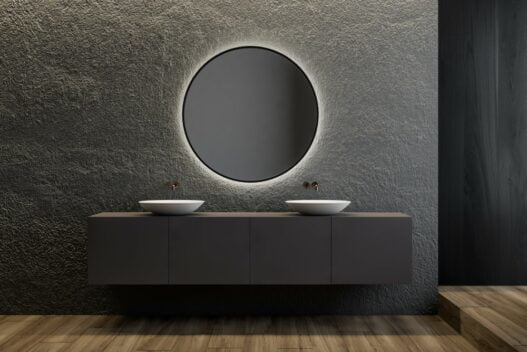 Rundt spejl med lys på et moderne badeværelse